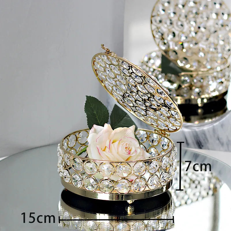 Transparent crystal glass jewelry storage box with ornate French gold metal frame.