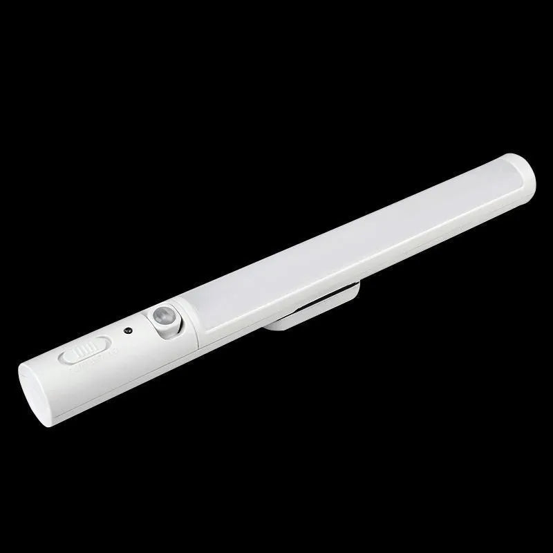 Slender white human body induction cabinet light with magnetic strip for mounting on metallic surfaces.