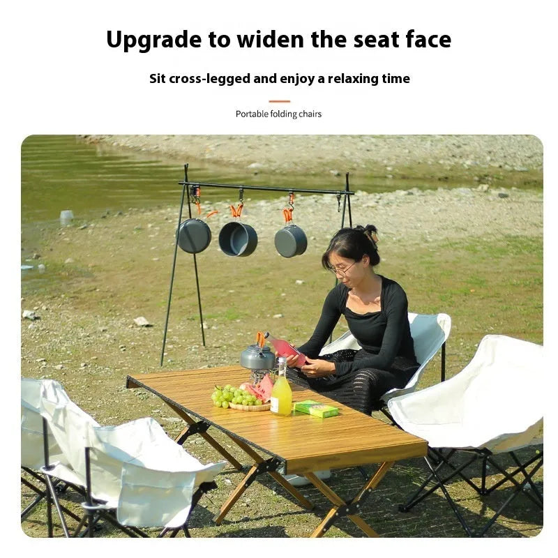Beige portable folding camping chair with steel frame on grass outdoors