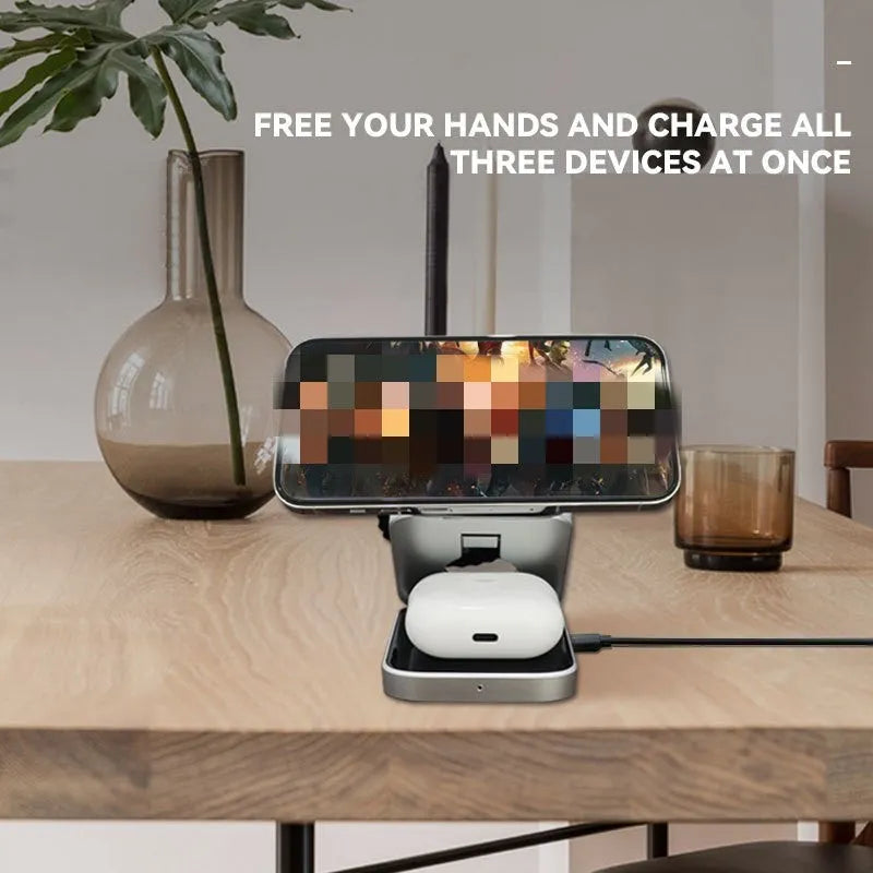 Three-in-one desktop wireless charging bracket unfolded on desk with iPhone, Samsung phone, and Google Pixel Watch positioned for charging