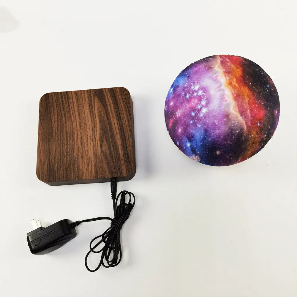 Magnetic levitation galaxy decorative light with floating moon lamp rotating above walnut-coloured base
