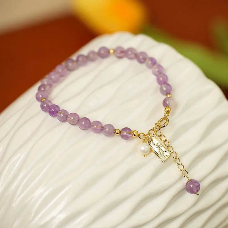 Women's natural crystal bracelet with lavender amethyst stones and animal zodiac design.