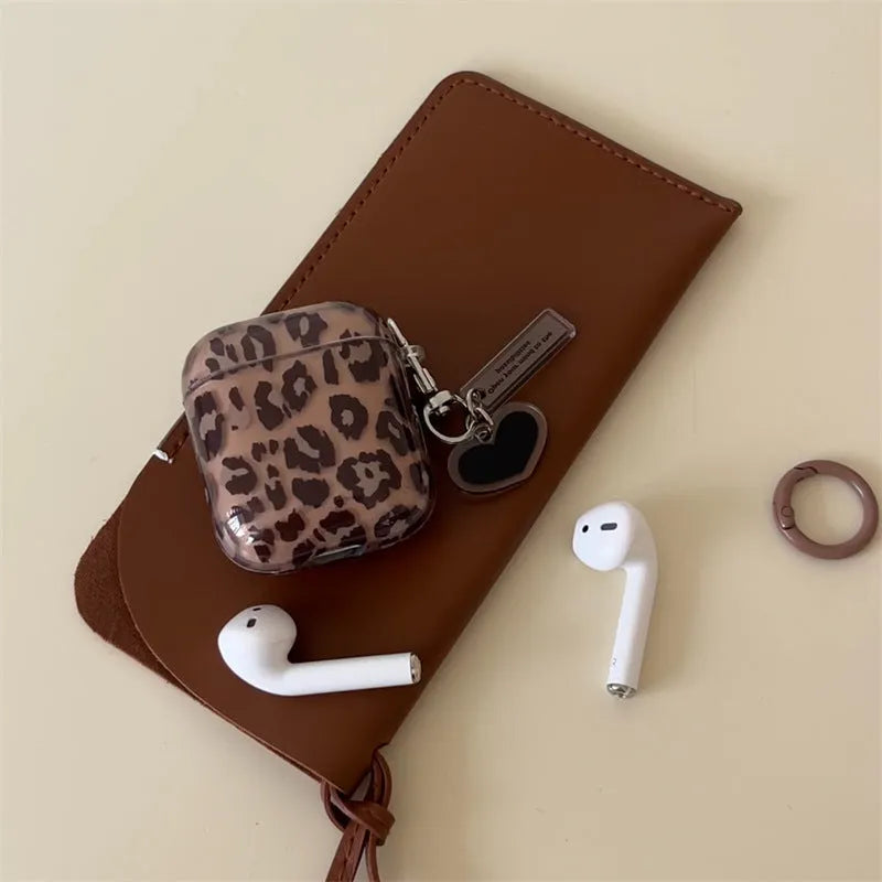 Transparent brown leopard printed PC earphone sleeve on Apple AirPods charging case showing visible logo and spotted pattern