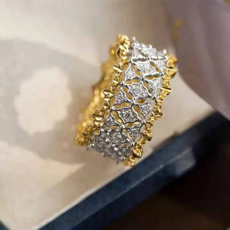 Gold and silver two-tone geometric ring with a central round zircon stone on a copper band.