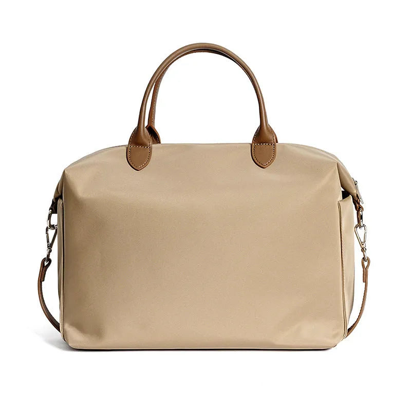 Black nylon waterproof shoulder bag with leather handles showing large open interior.