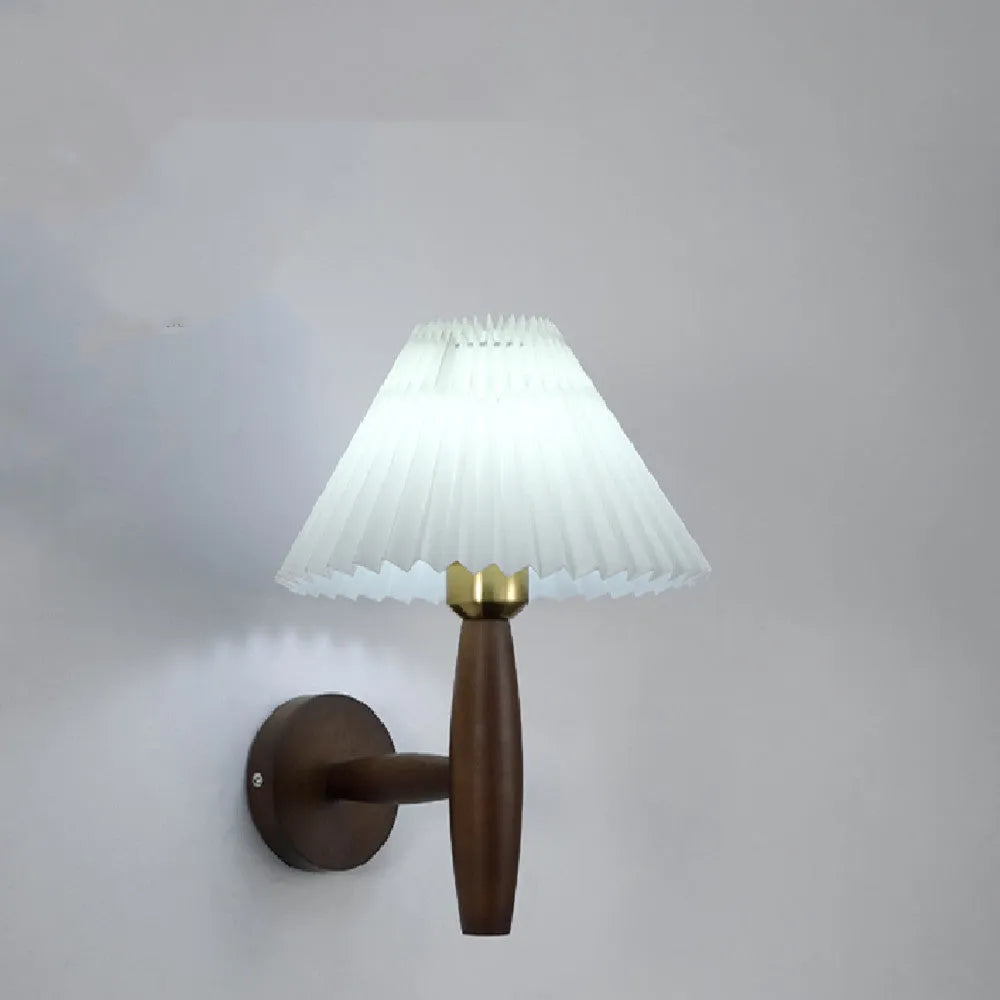 American retro rubber wood and fabric wall lamp in walnut finish on a wall.