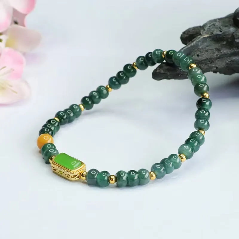 Natural stone blue water jade beaded bracelet with round and oval geometric beads on a white background