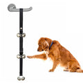 Adjustable dog training doorbell with silver metal bells on a black nylon leash, hung on a door.