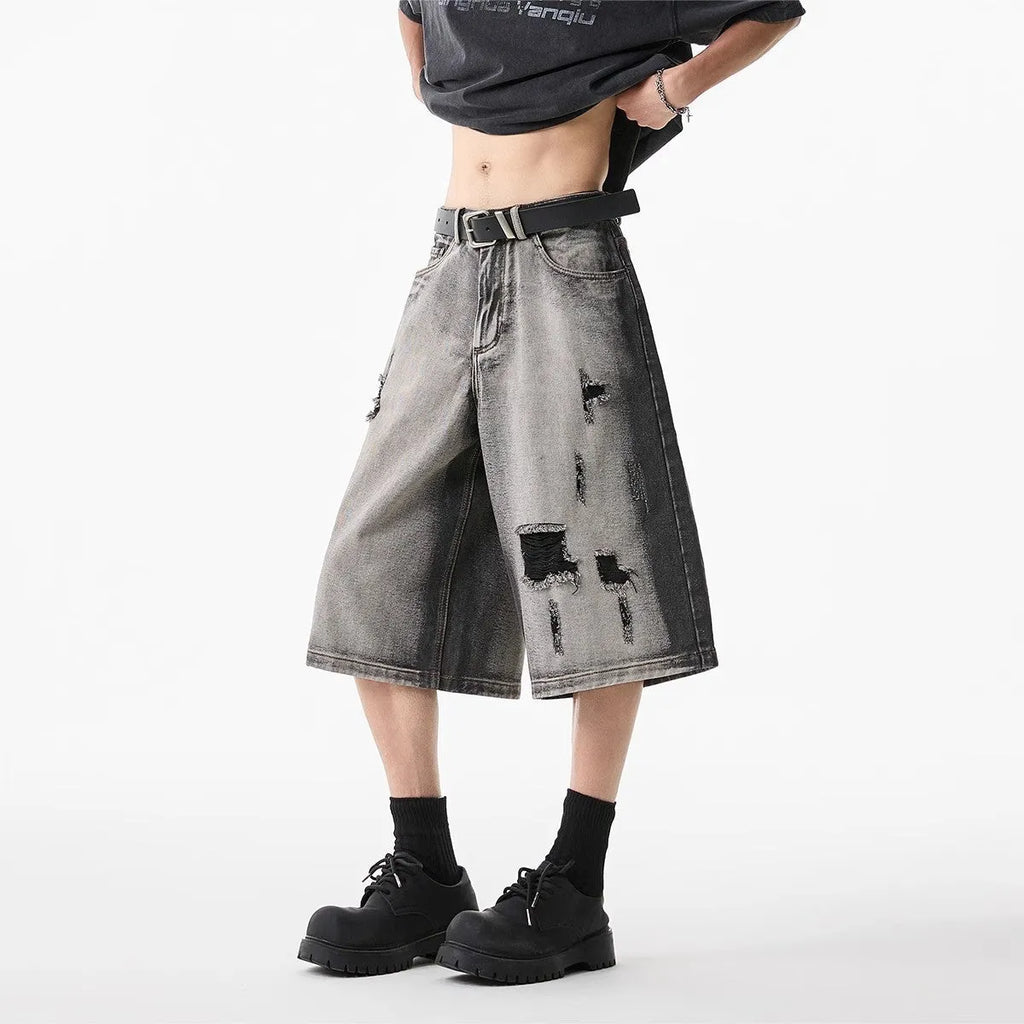 Grey denim shorts with loose fit and cropped length on hanger