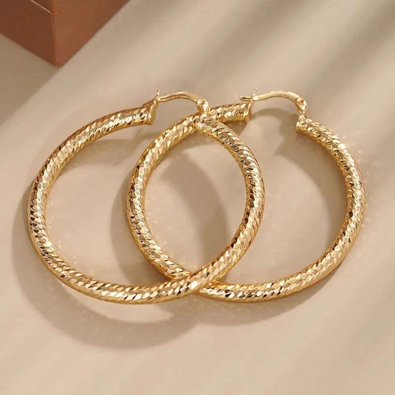A pair of women's geometric drop-shaped clip-on earrings with a ring design in an electroplated copper finish.