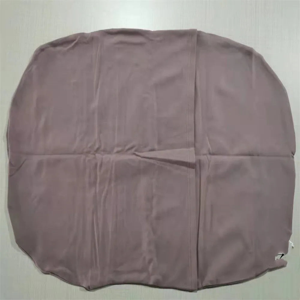 Beige portable cotton baby nest crib for newborns on a neutral background