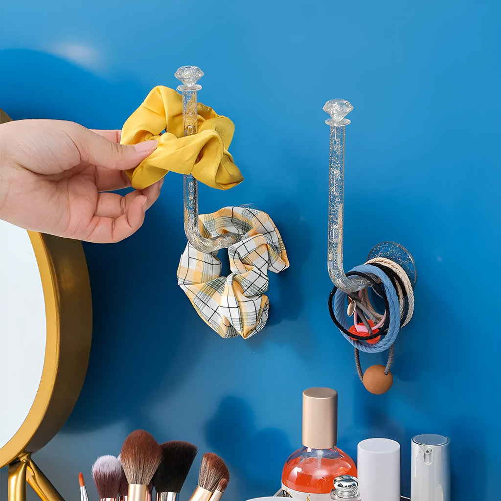 White plastic diamond crystal storage hook mounted on wall holding keys and small accessories