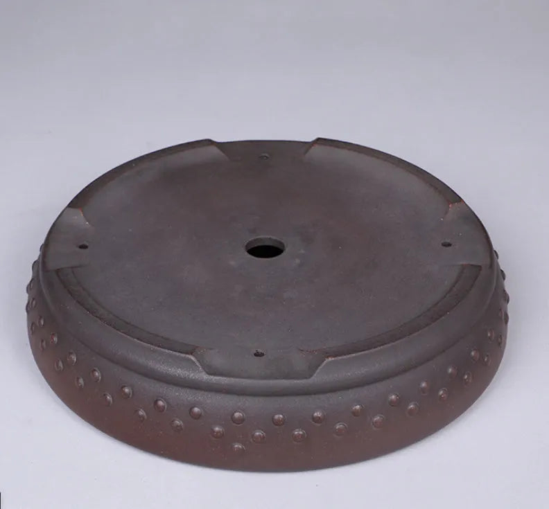 Classical handmade purple clay ceramic flowerpot with large round mouth on a wooden table