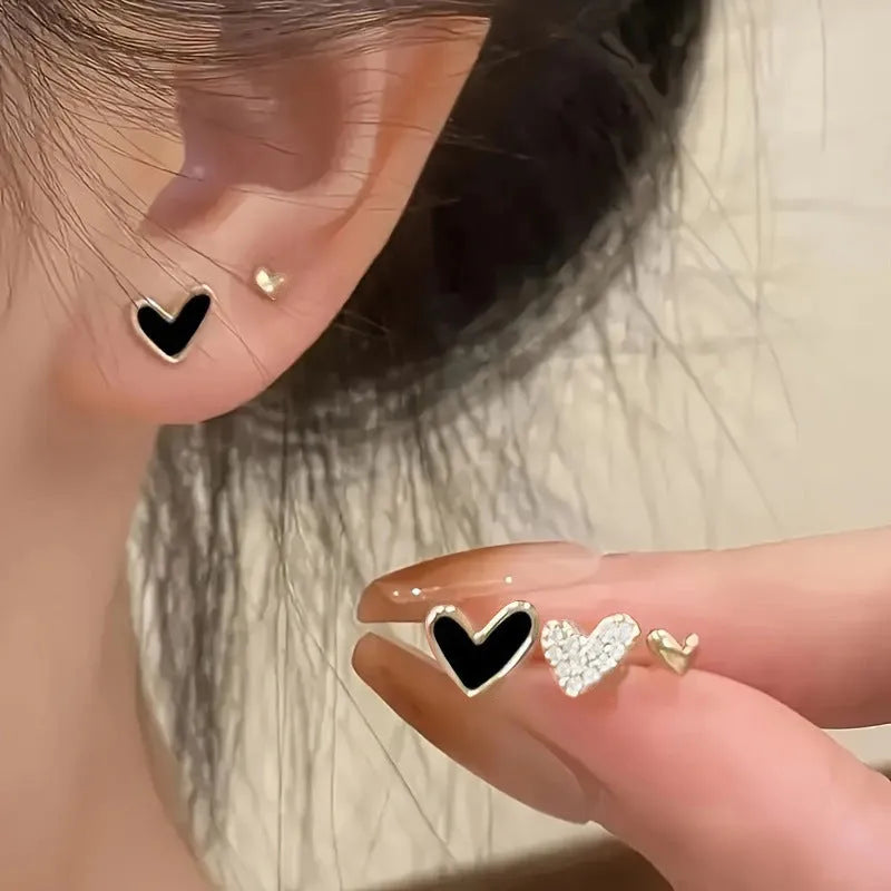 Three pairs of heart-shaped alloy earrings with electroplated finishes in gold, black, black-white, and pink colours