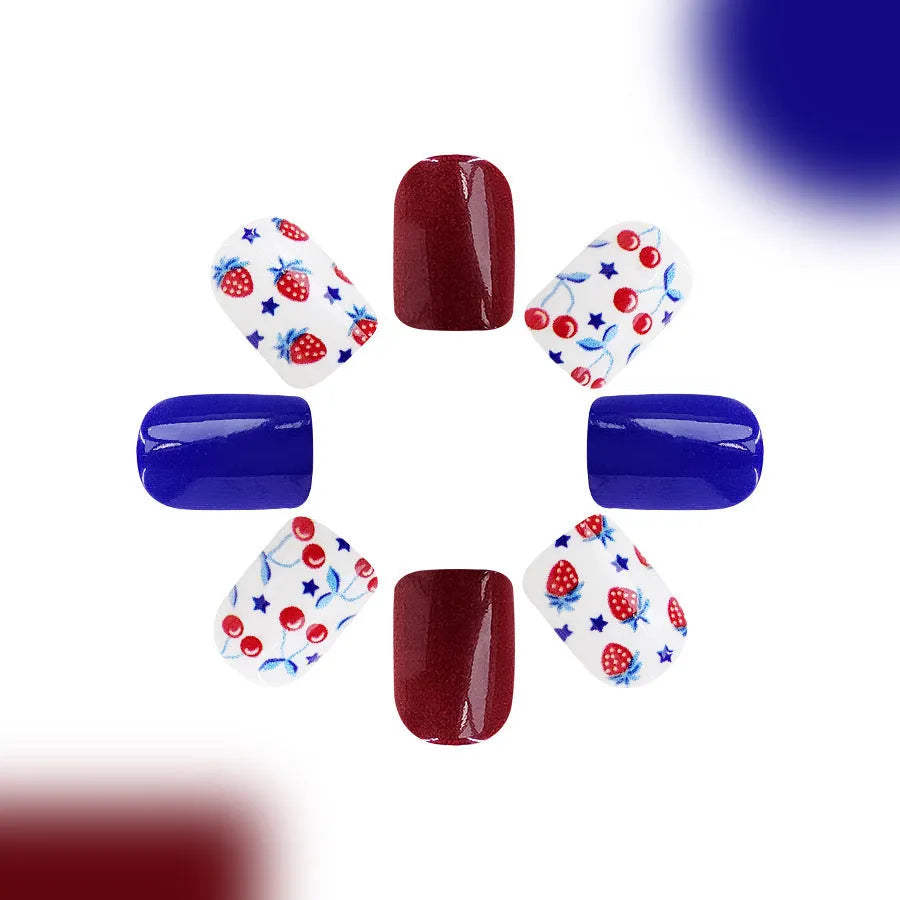 Short glossy false nails with strawberry cherry independence day pattern in red and blue colours