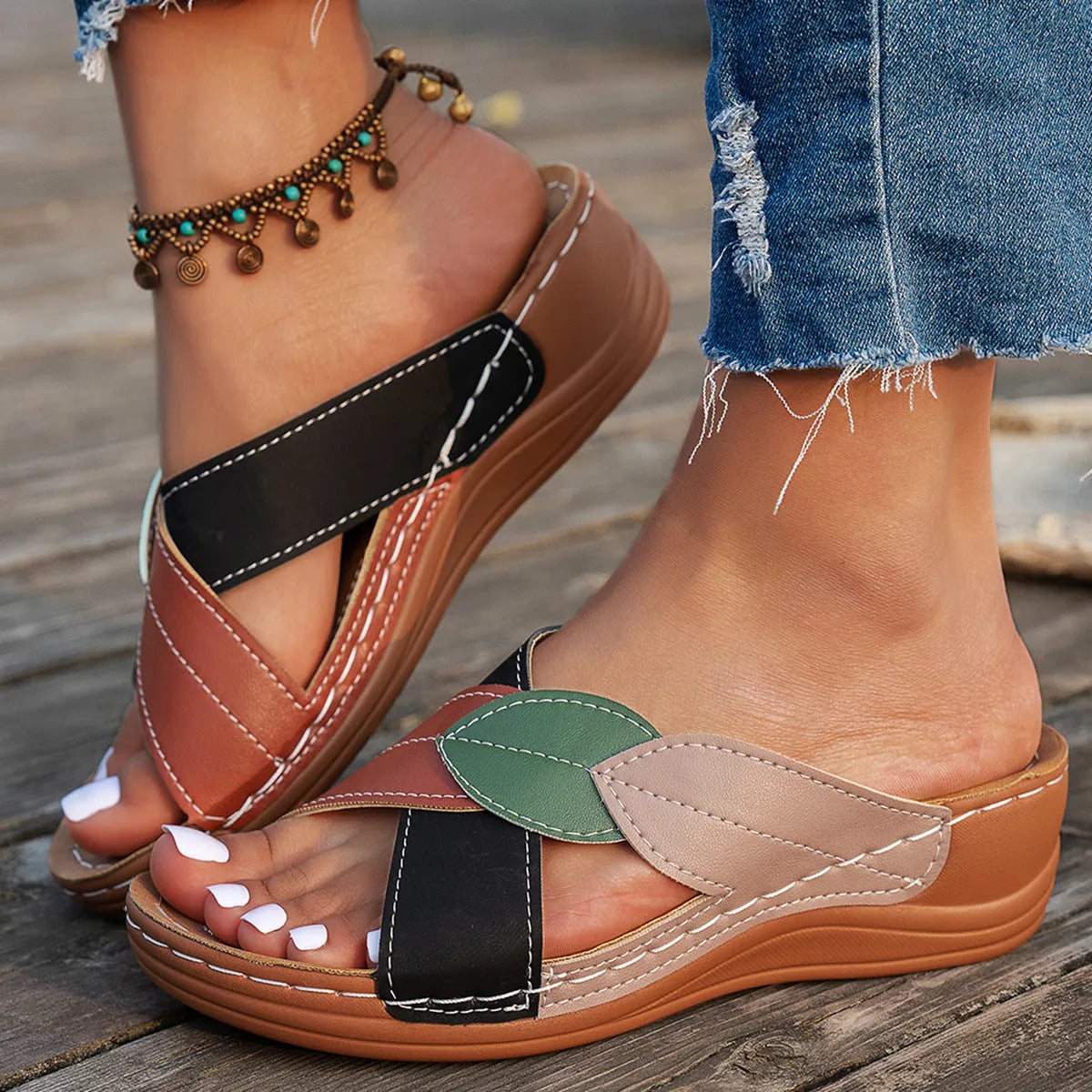Women's black thick-soled slippers with cross-straps and a peep-toe opening on a white background.