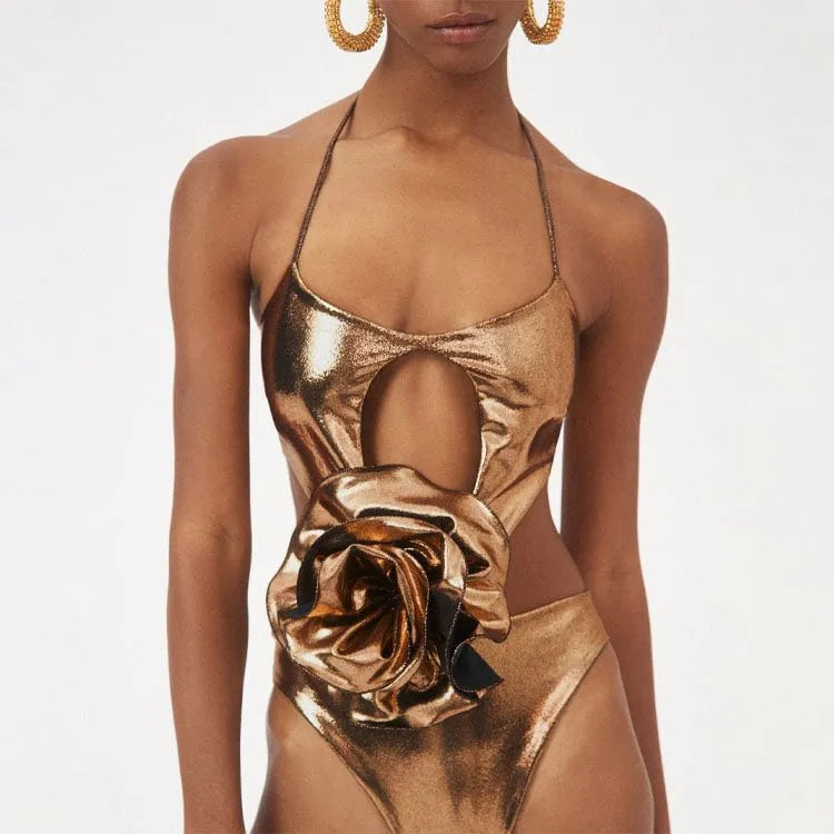 Gold coloured handmade one-piece swimsuit with halter neckline and hollow-out design on a mannequin.