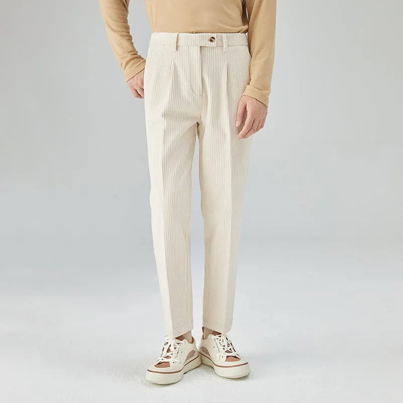 Men's straight-leg corduroy trousers in beige, shown laid flat to display the mid-waist and textured fabric.