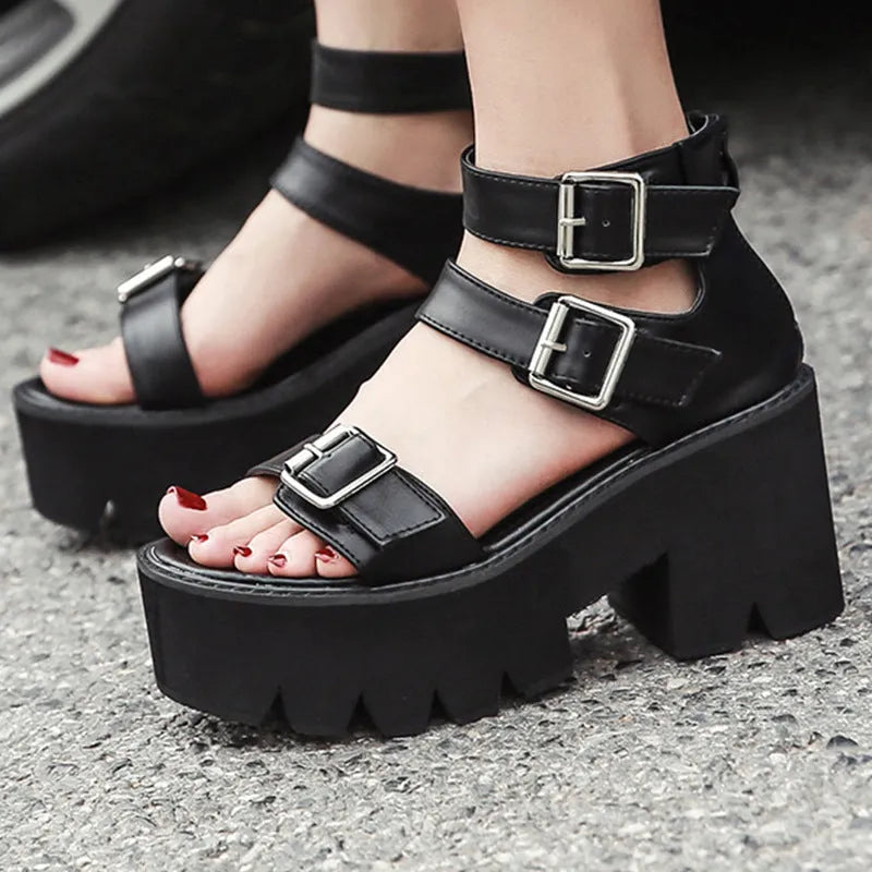 Black women's punk-style Roman sandals with a chunky platform heel and a back zipper closure.