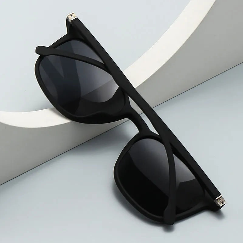 Men's polarised sunglasses with a black frame, dark green lenses, and an elastic grip spectacle foot.