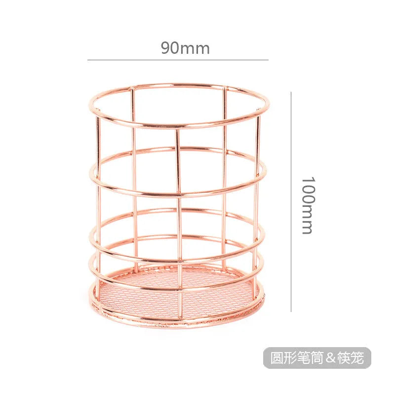 Rose gold iron wire square pen holder on desk holding pens and a ruler