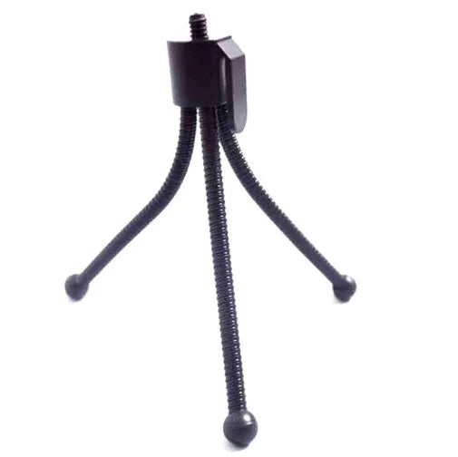 Small silver mini tripod with ball head shown extended on a desktop next to a mobile phone.