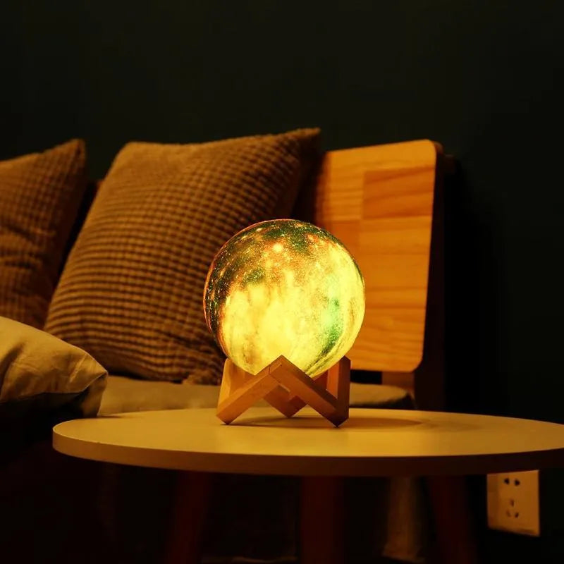 3D printed spherical moon night light glowing with multi-colour LED light on a dark surface.