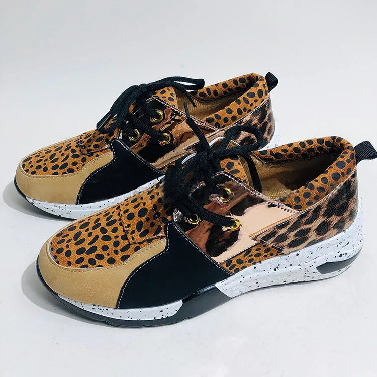 Women's black casual flat sneakers with suede upper and a wedge heel on a breathable fabric base.