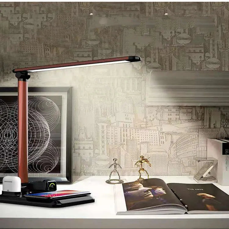 Black 4-in-1 LED desk lamp with adjustable arm and integrated wireless charging station on base