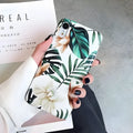 Soft TPU iPhone case with detailed floral and banana leaf art in green tones on the back.