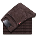 Men's straight slim-fit corduroy trousers in black, cotton fabric, side view on model