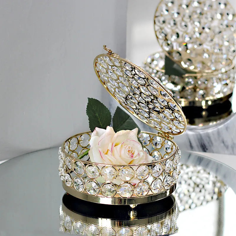 Transparent crystal glass jewelry storage box with ornate French gold metal frame.