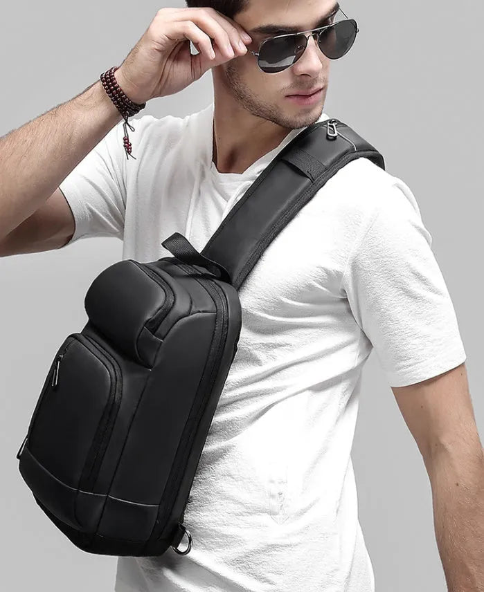 Black medium outdoor shoulder bag showing computer pocket, soft handle, and single air cushion strap.