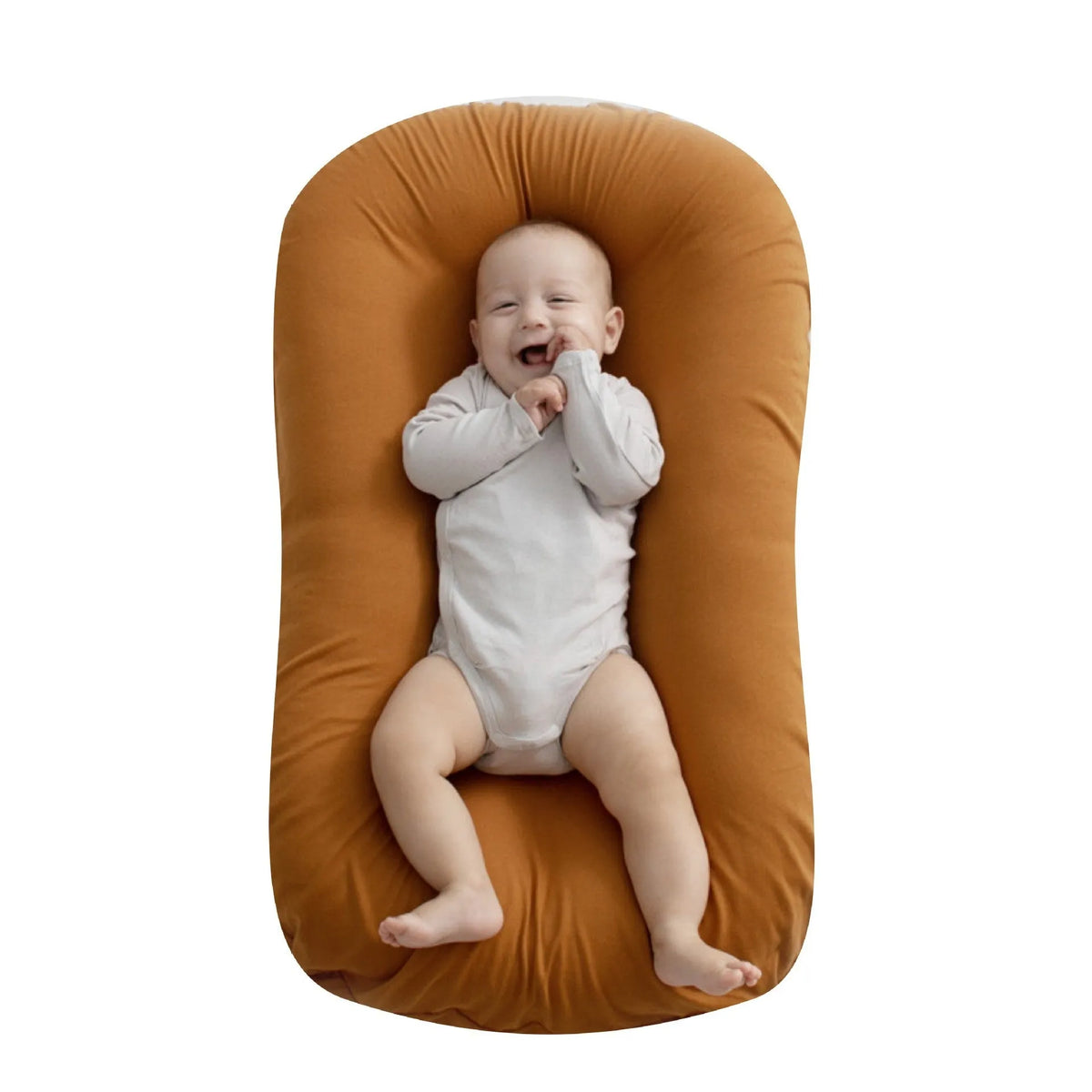 Beige portable cotton baby nest crib for newborns on a neutral background