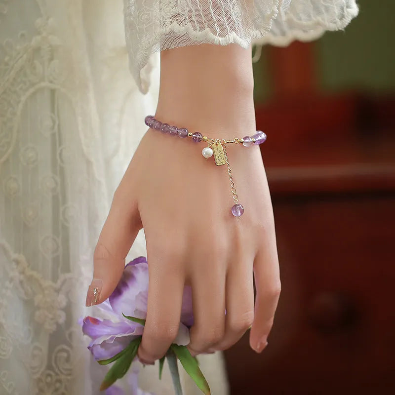 Women's natural crystal bracelet with lavender amethyst stones and animal zodiac design.