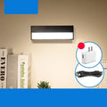 Black and white magnetic rechargeable LED desk lamp with touch dimming on a wooden desk.