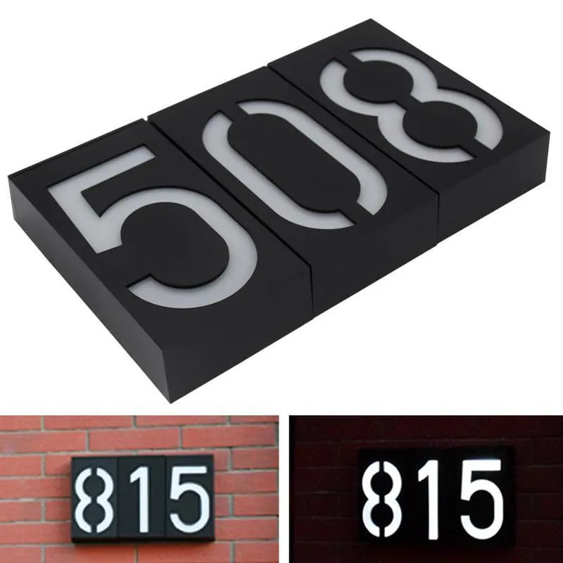 Solar powered illuminated house number light with digit '3' showing, mounted on a wall.