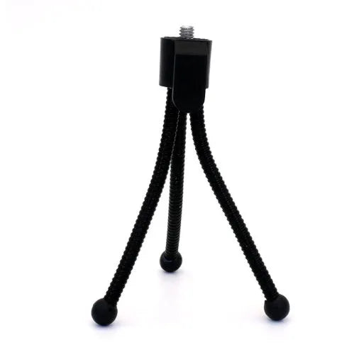 Small silver mini tripod with ball head shown extended on a desktop next to a mobile phone.
