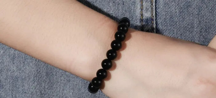 Geometric black onyx bracelet with 8mm agate beads on a black elastic cord.