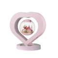Pink preserved rose ornament gift with optional Bluetooth audio base on a wooden table.