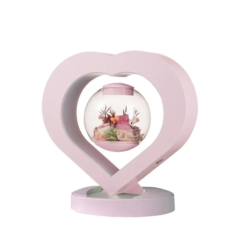 Pink preserved rose ornament gift with optional Bluetooth audio base on a wooden table.