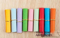 Assorted coloured paper scrolls in small sizes with a metal eyelet for hanging.