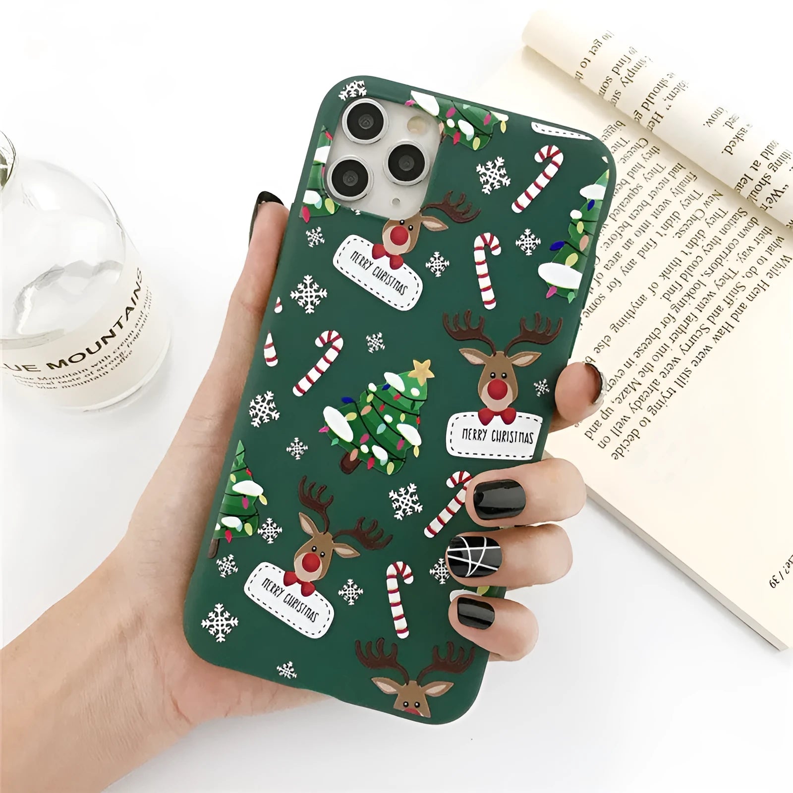 Green TPU iPhone case with a cartoon Christmas elk and tree design beside stripes.