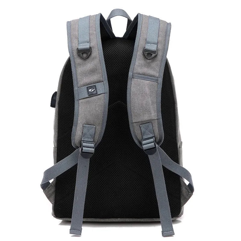 Canvas backpack with USB charging port showing laptop compartment and multiple pockets in grey colour