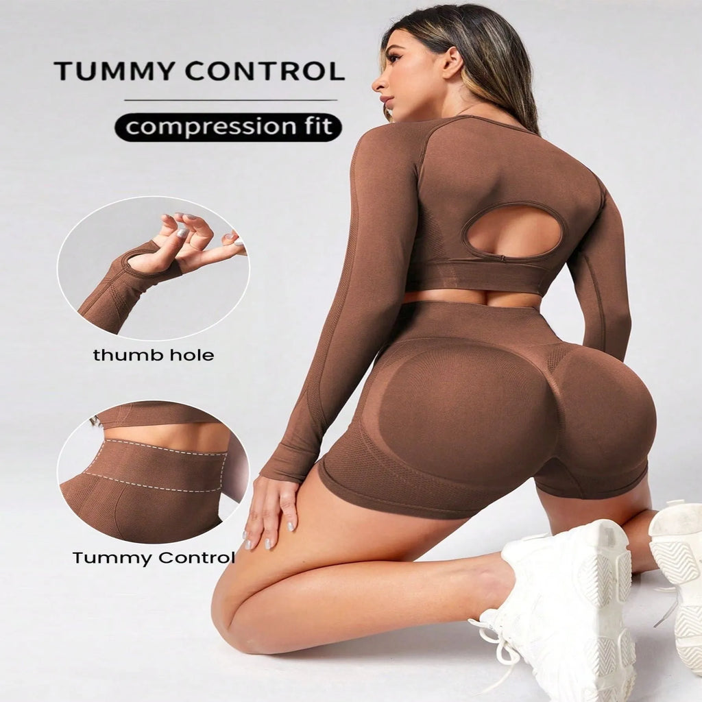 Women's black yoga set comprising a long sleeve top and high-waist trousers laid flat.