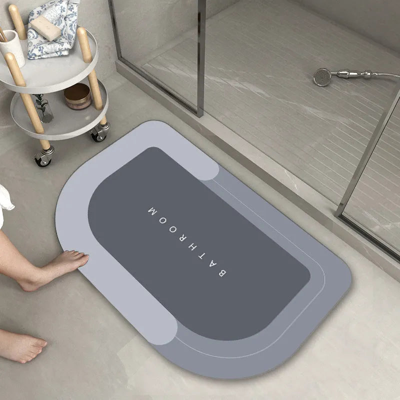 Blended fibre machine woven bathroom floor mat in blue, shown in an oval shape on a tiled floor.