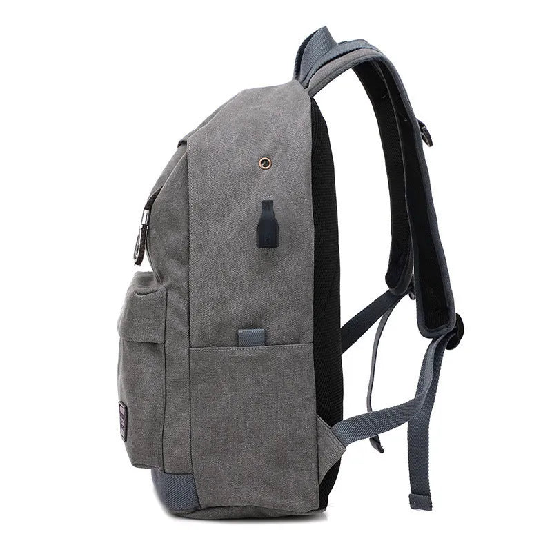 Canvas backpack with USB charging port showing laptop compartment and multiple pockets in grey colour