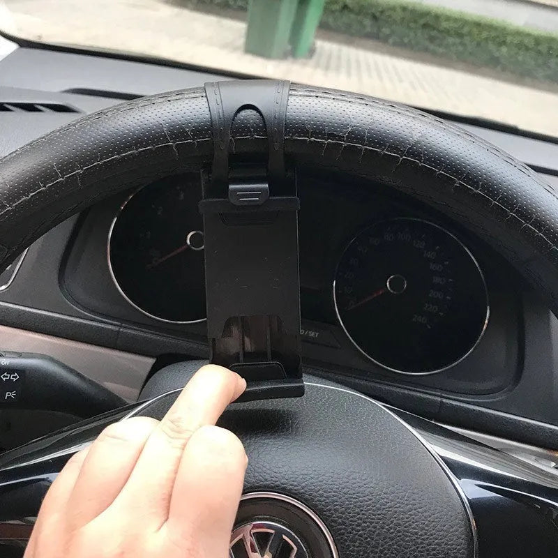 Black steering wheel phone clip mount holding smartphone with soft silicone padding visible