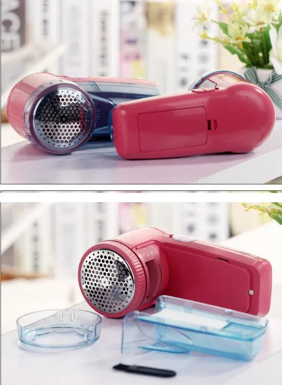 Portable electric clothing lint remover device on a table next to a sweater.