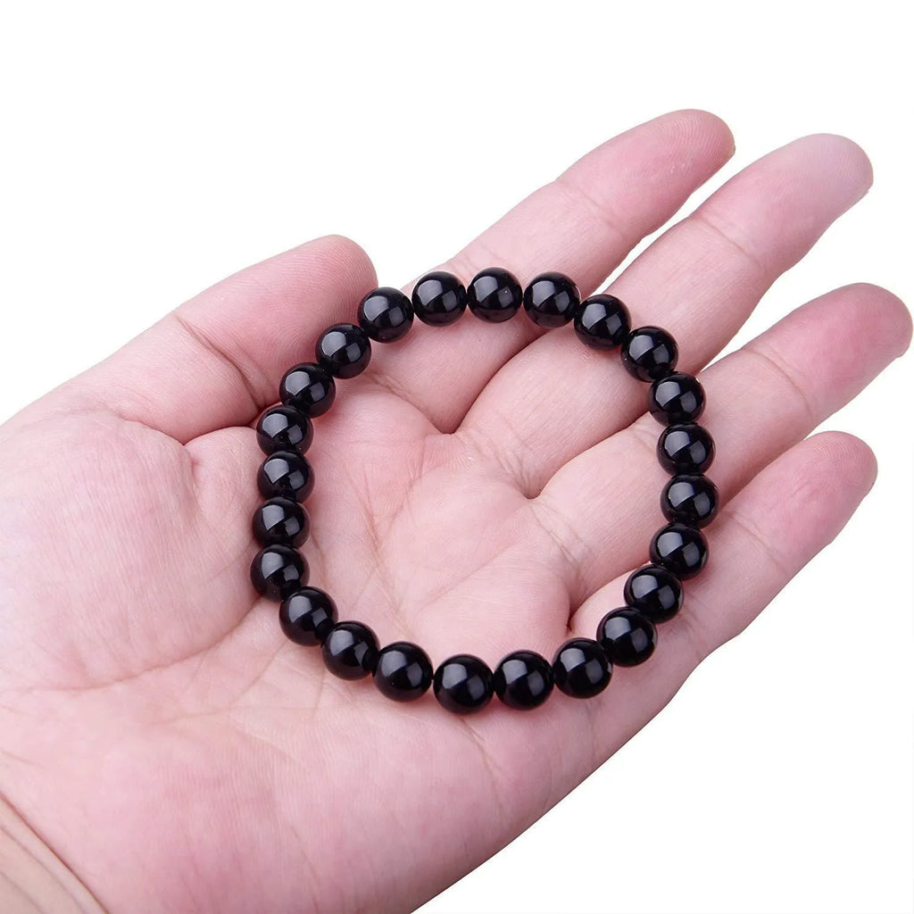 Geometric black onyx bracelet with 8mm agate beads on a black elastic cord.